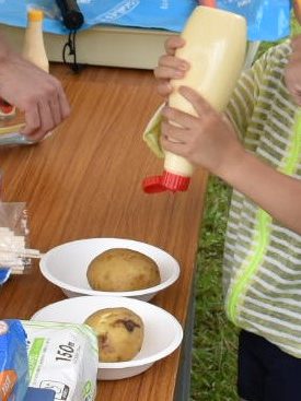マヨネーズを付けてジャガイモを食べる姿の画像